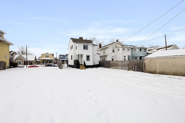 view of snow covered back of property