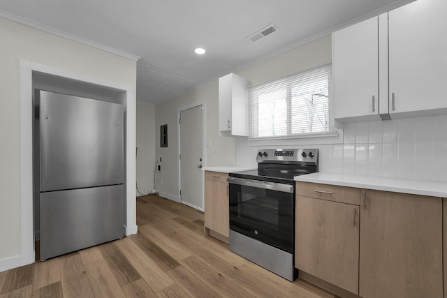 kitchen featuring white cabinetry, stainless steel appliances, backsplash, light wood-type flooring, and ornamental molding