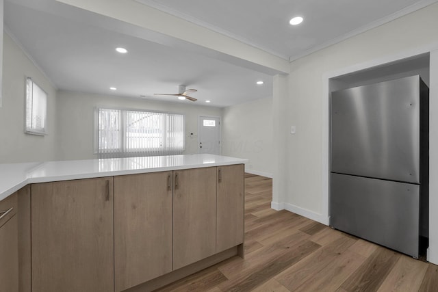 kitchen featuring ceiling fan, light hardwood / wood-style flooring, ornamental molding, light brown cabinetry, and stainless steel fridge