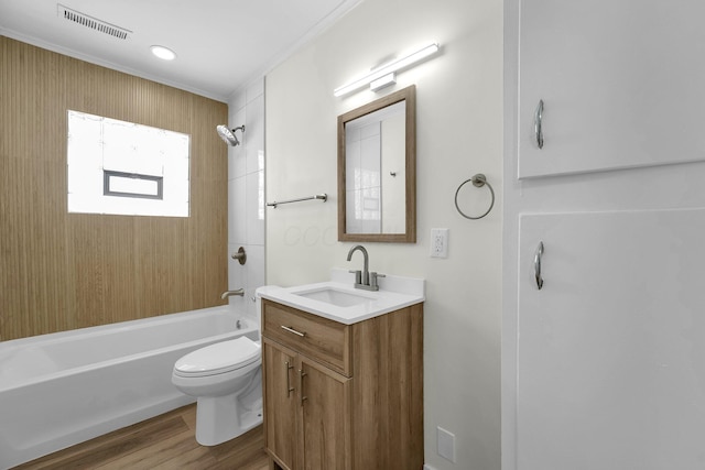 full bathroom featuring toilet, vanity, hardwood / wood-style flooring, ornamental molding, and bathing tub / shower combination