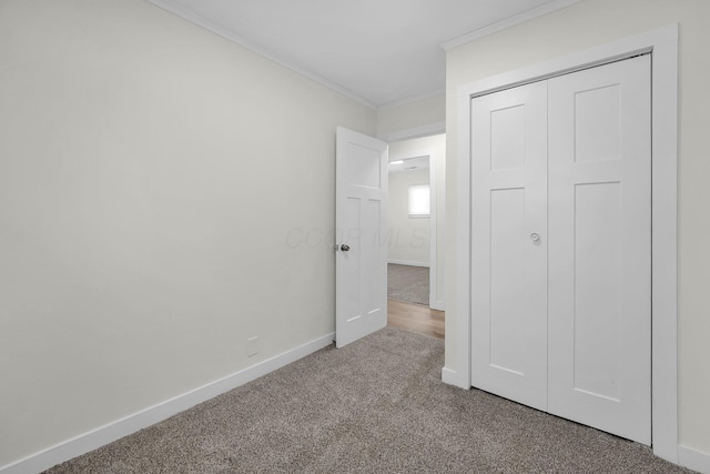 unfurnished bedroom with a closet, crown molding, and carpet flooring