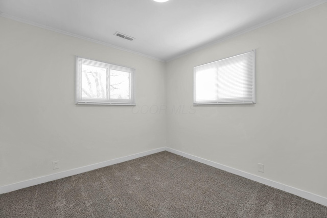 spare room with dark colored carpet and ornamental molding