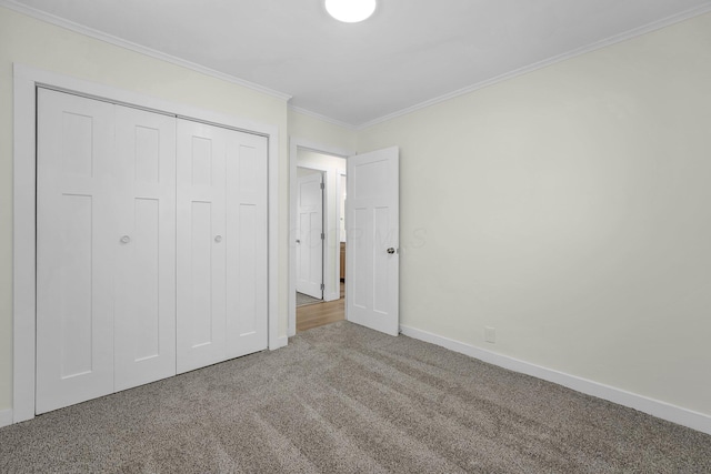 unfurnished bedroom with carpet floors, a closet, and ornamental molding