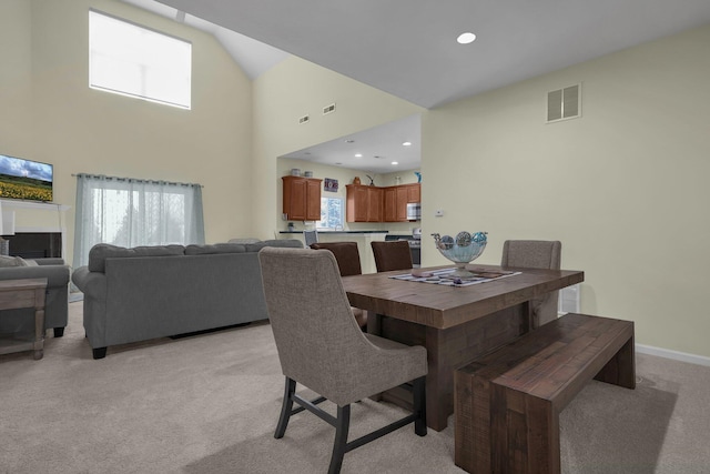 carpeted dining area with a high ceiling