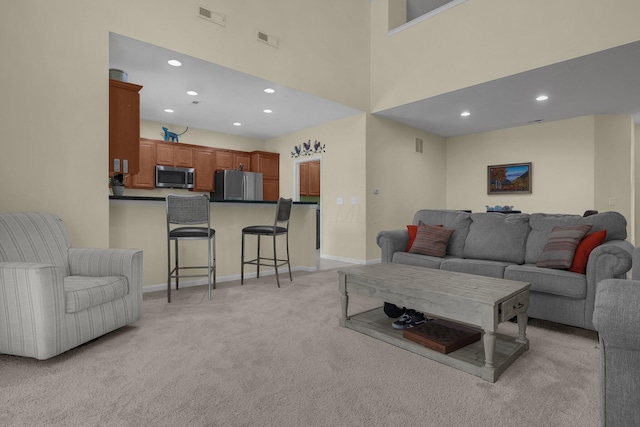 carpeted living room with a high ceiling