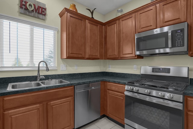 kitchen featuring sink, light tile patterned floors, and stainless steel appliances