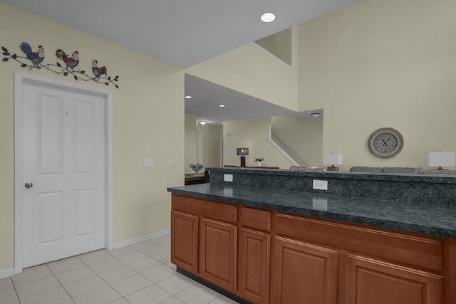 kitchen with light tile patterned floors and dark stone counters