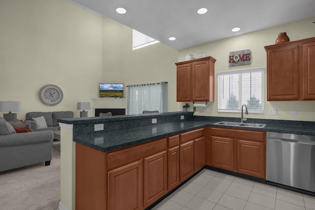 kitchen featuring sink, dishwasher, light colored carpet, and kitchen peninsula