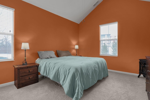 bedroom featuring a wood stove, light colored carpet, and lofted ceiling