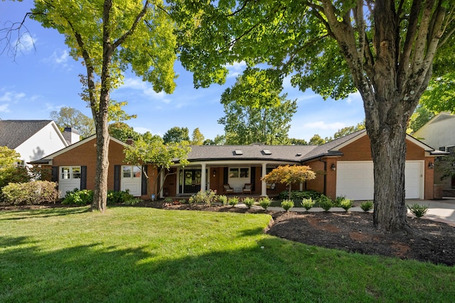 single story home with a front yard, covered porch, and a garage