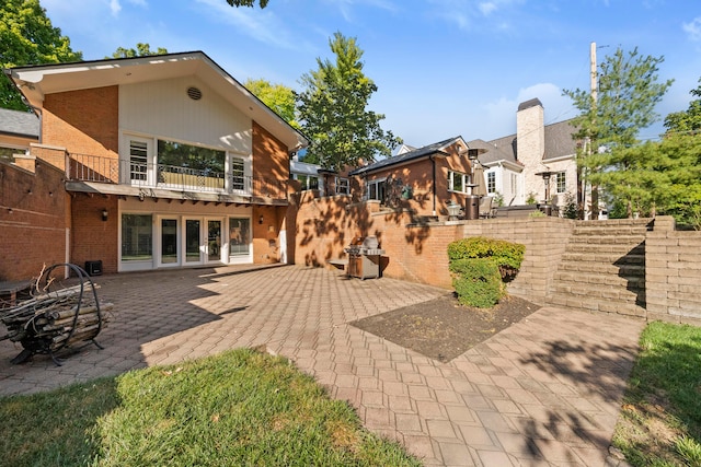 rear view of house featuring a balcony and a patio