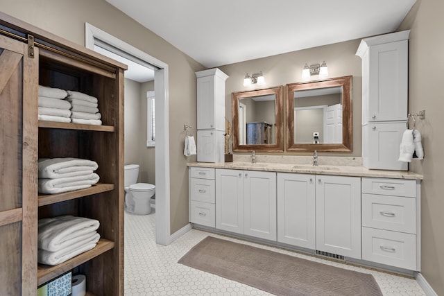 bathroom with toilet, tile patterned flooring, and vanity