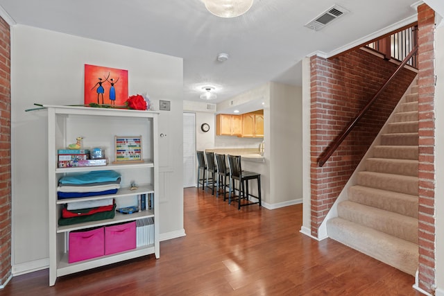 interior space with dark hardwood / wood-style floors, light brown cabinets, and a breakfast bar area