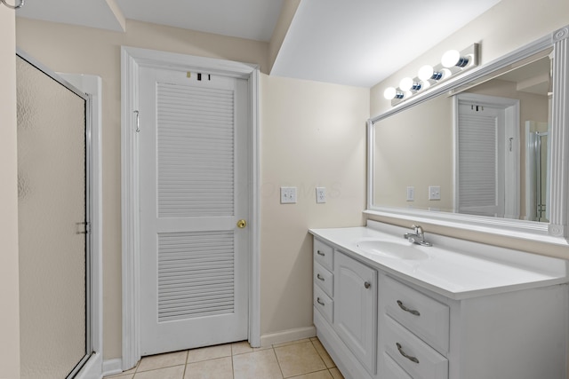 bathroom featuring tile patterned flooring, a shower with shower door, and vanity