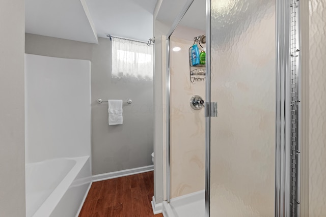 bathroom featuring shower with separate bathtub and wood-type flooring