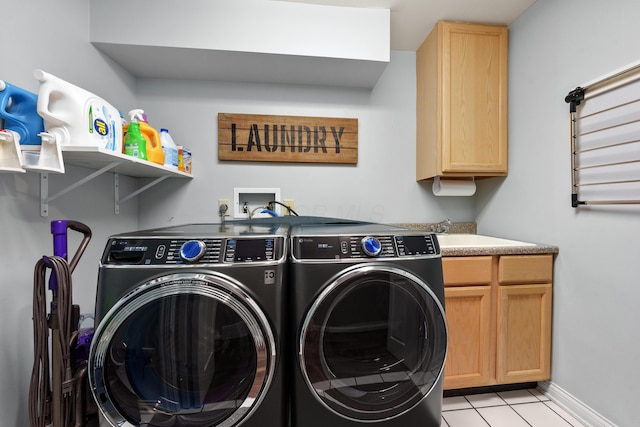 clothes washing area featuring cabinets, sink, washing machine and dryer, and light tile patterned flooring