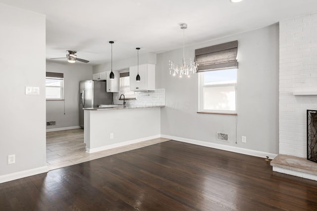 kitchen featuring ceiling fan with notable chandelier, white cabinetry, dark hardwood / wood-style floors, and kitchen peninsula