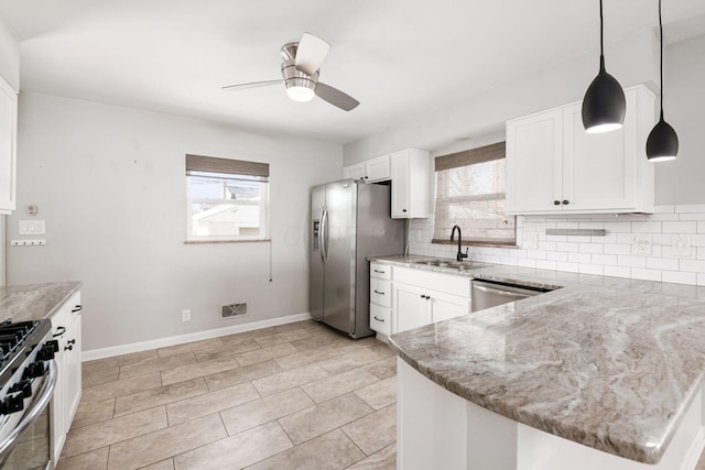 kitchen with tasteful backsplash, decorative light fixtures, sink, appliances with stainless steel finishes, and white cabinets