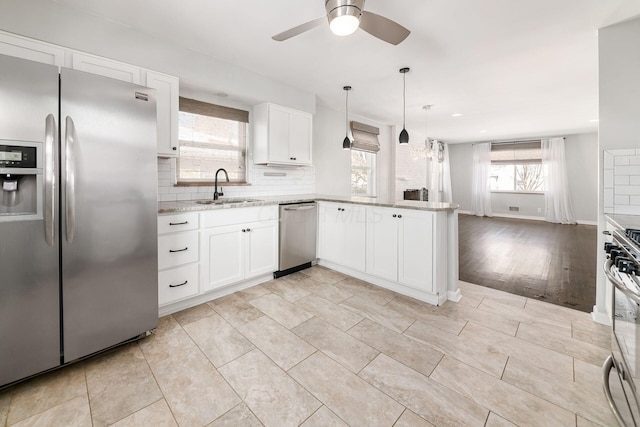 kitchen with decorative light fixtures, ceiling fan, sink, white cabinetry, and stainless steel appliances