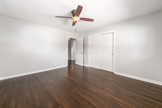 unfurnished bedroom with ceiling fan, dark wood-type flooring, and a closet