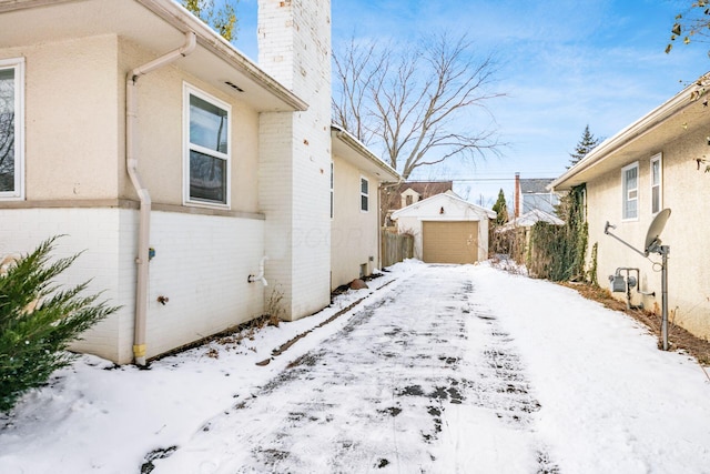 snow covered property with a storage unit