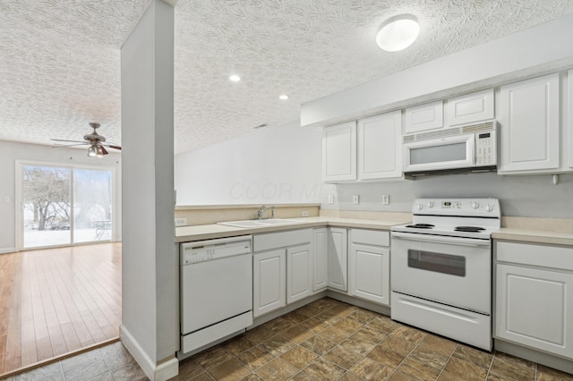 kitchen featuring white appliances, ceiling fan, white cabinetry, and sink