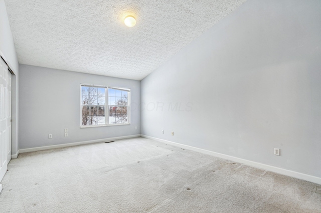 unfurnished bedroom featuring a textured ceiling and light carpet