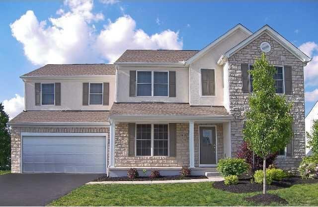 traditional home featuring stucco siding, aphalt driveway, stone siding, a shingled roof, and a garage