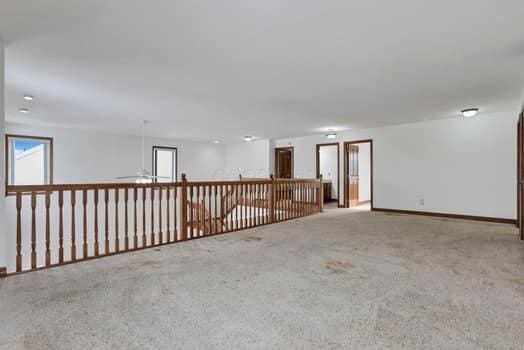 empty room featuring carpet flooring and baseboards