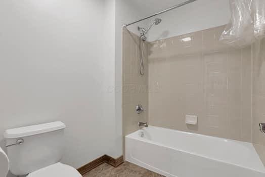 bathroom with toilet and shower / washtub combination