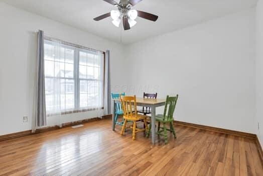 dining space featuring baseboards, wood finished floors, and a ceiling fan