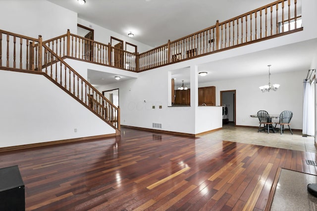 living room with a notable chandelier, visible vents, and hardwood / wood-style floors