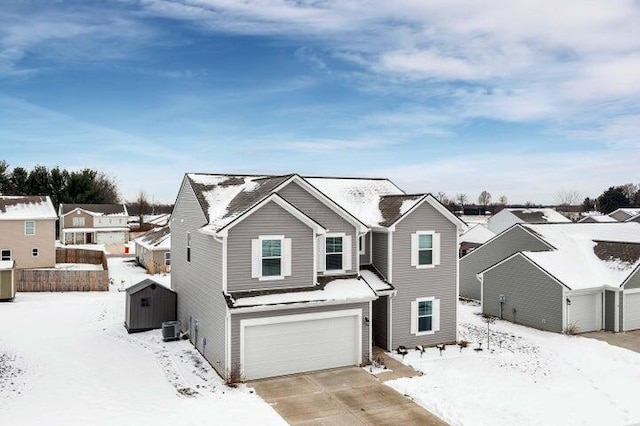 traditional-style home with a residential view, a garage, cooling unit, driveway, and an outdoor structure