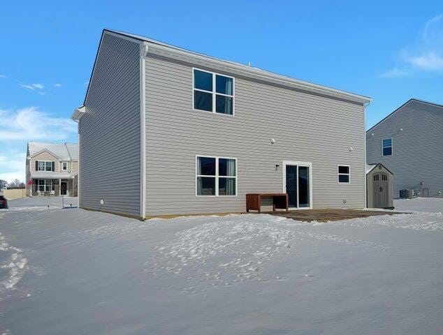 snow covered property featuring central AC