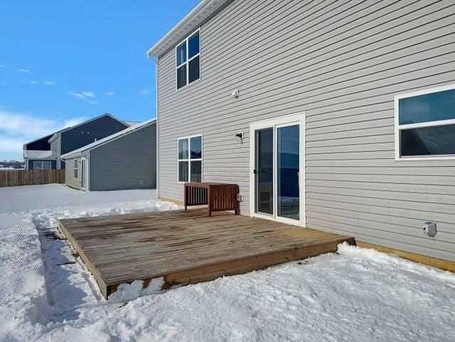 snow covered rear of property with a wooden deck