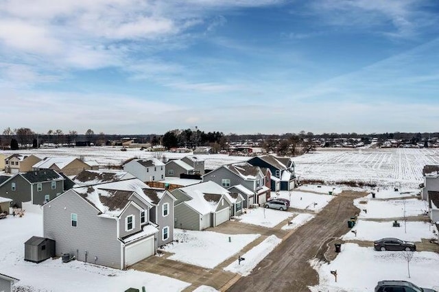 snowy aerial view with a residential view