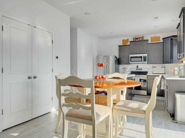 kitchen with light wood-type flooring, stainless steel appliances, and light countertops