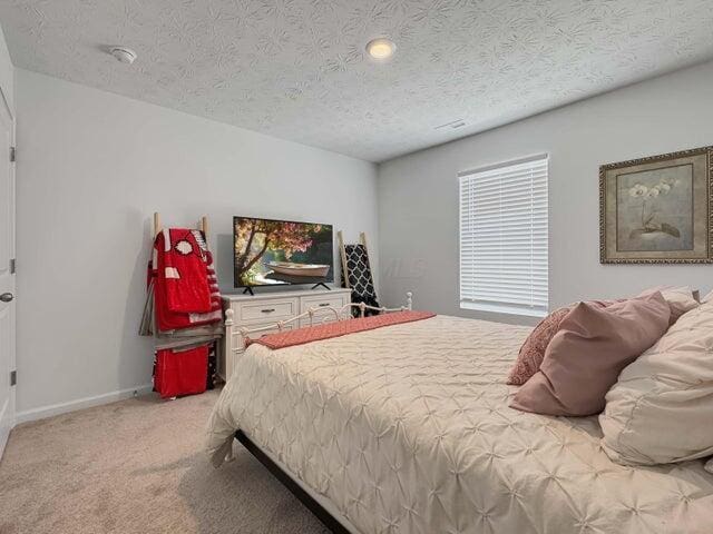 carpeted bedroom with a textured ceiling and baseboards