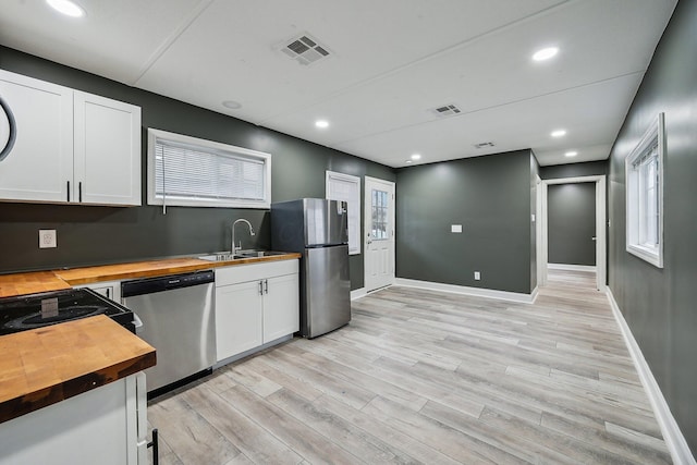 kitchen featuring stainless steel appliances, light wood-type flooring, wood counters, white cabinetry, and sink