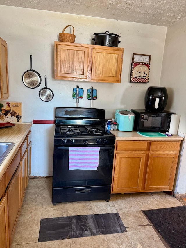 kitchen with black gas range and a textured ceiling