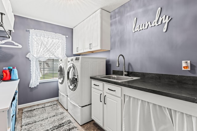 clothes washing area featuring cabinets, separate washer and dryer, and sink