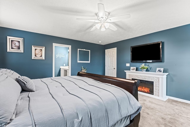 bedroom featuring ceiling fan, light colored carpet, a textured ceiling, and ensuite bath