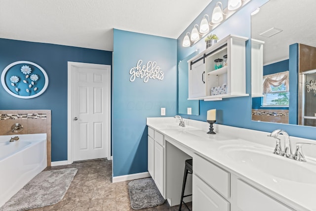 bathroom featuring a textured ceiling, vanity, and a bathing tub