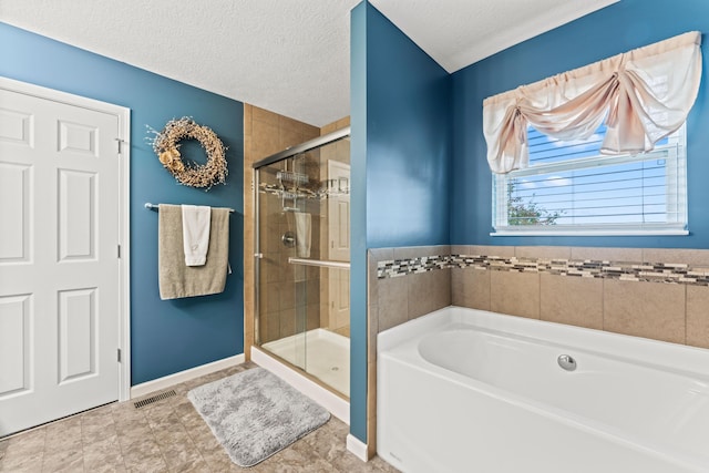 bathroom featuring separate shower and tub and a textured ceiling