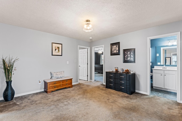 carpeted bedroom with sink, connected bathroom, and a textured ceiling