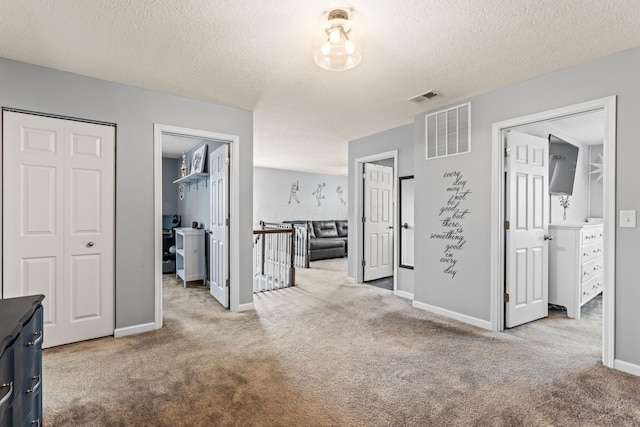 hall featuring light colored carpet and a textured ceiling