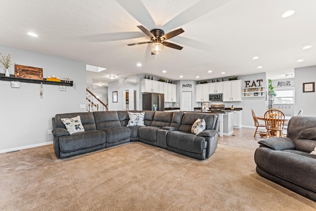 carpeted living room with ceiling fan