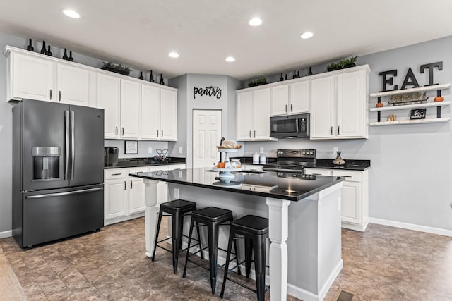 kitchen with range with electric cooktop, white cabinets, and stainless steel fridge