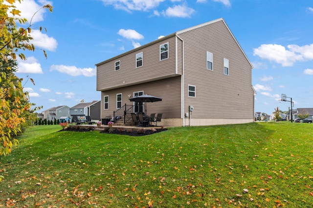 rear view of property featuring a patio area and a yard