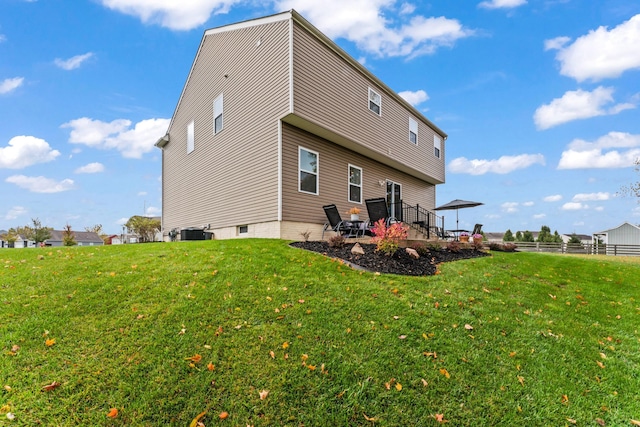 back of property featuring a lawn and central AC